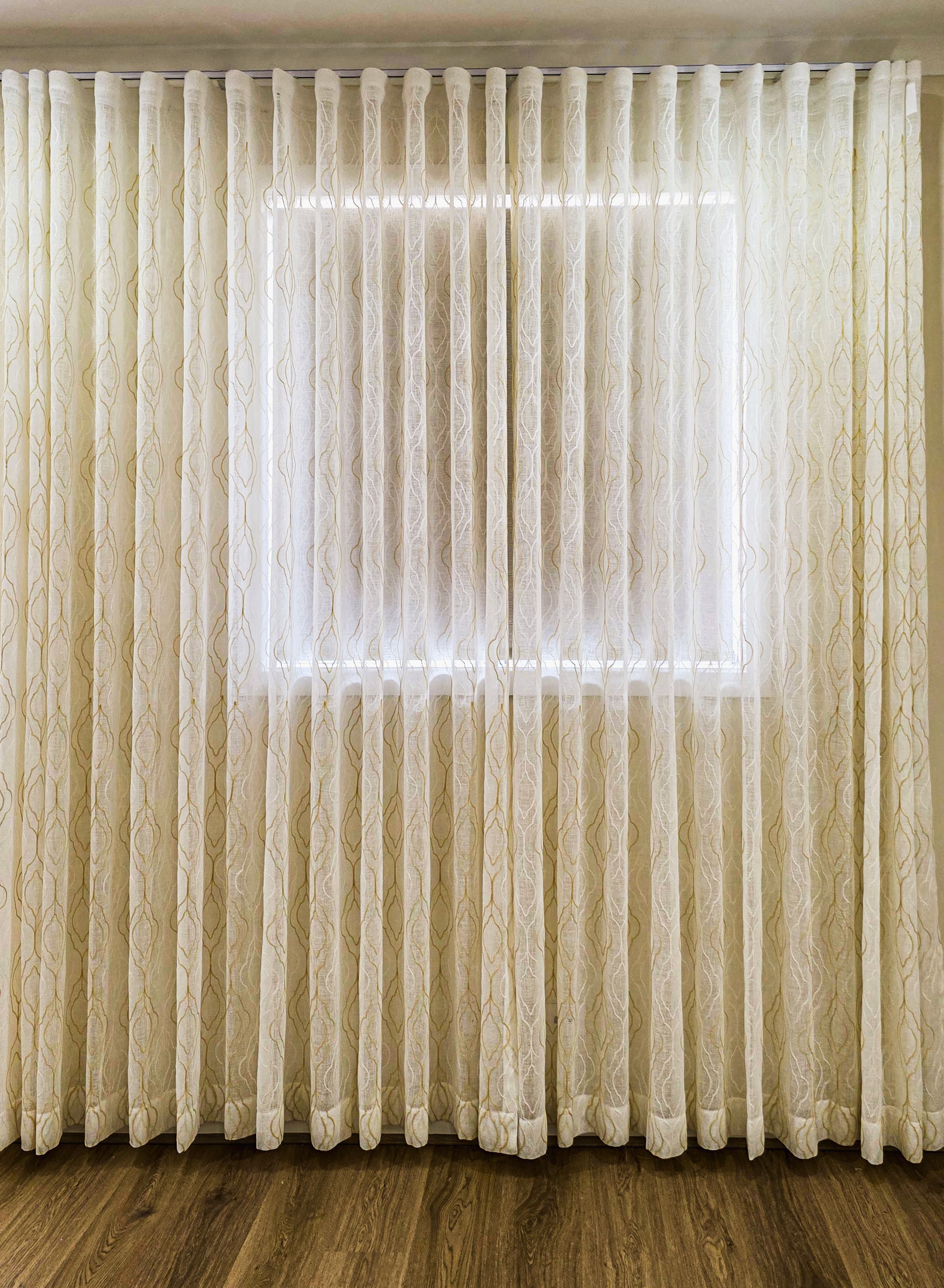 Beautiful S-fold sheer curtains spanning across a wide living area