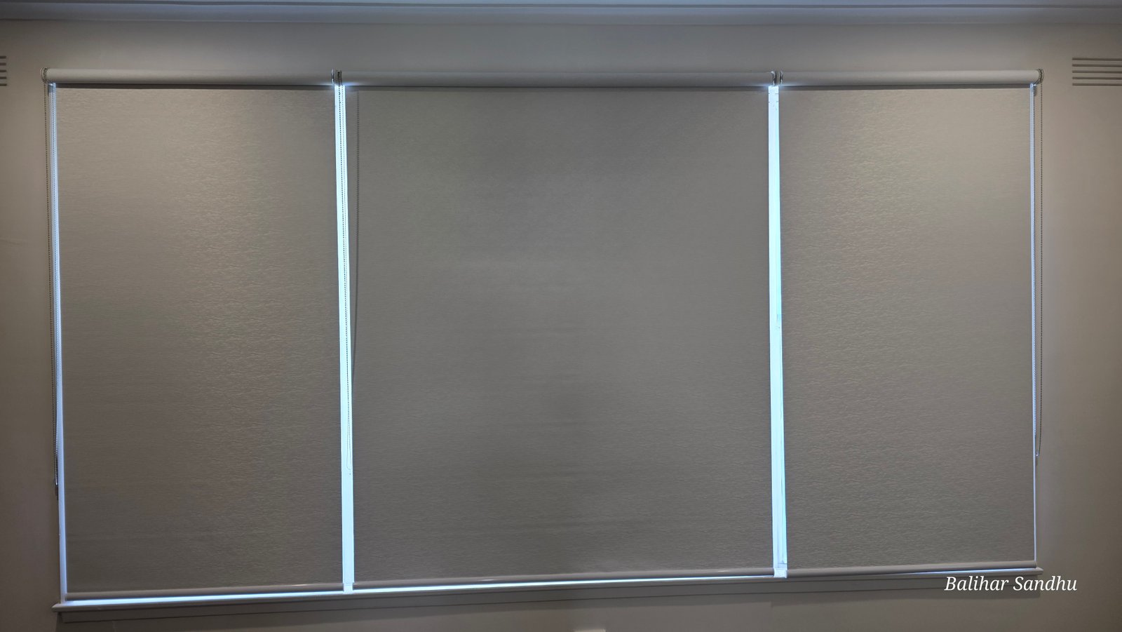 Triple blockout roller blinds installed on wide bay window