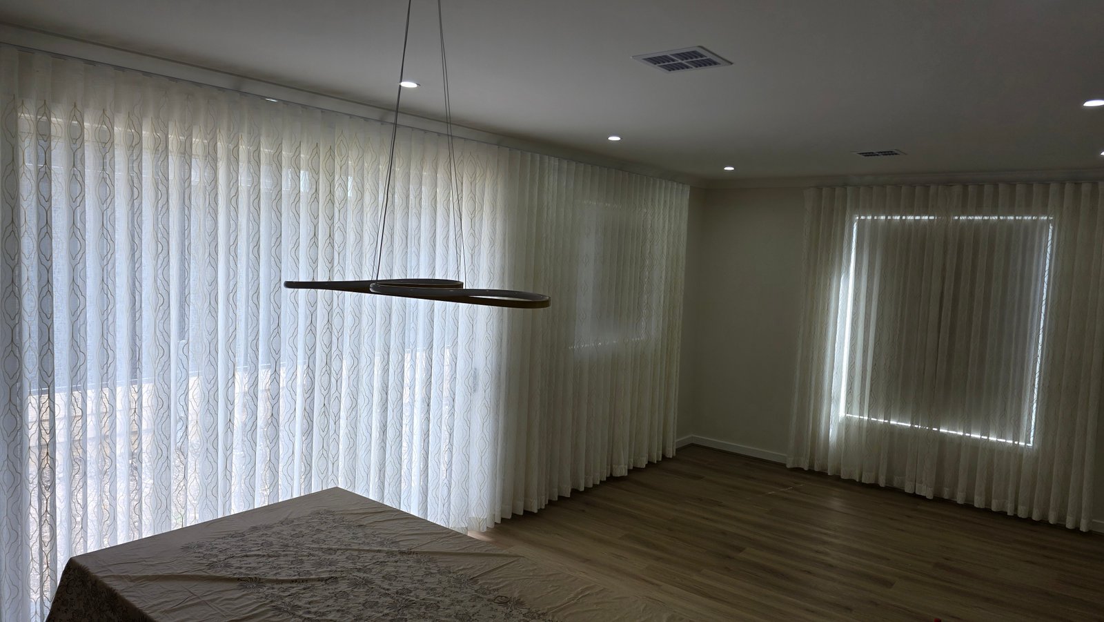 Sheer S-fold curtains spanning full wall of dining room